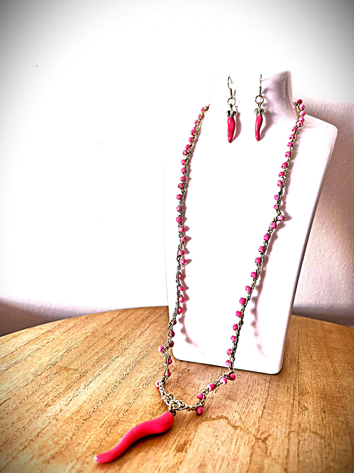 collana con piccole perline e corno rosa con orecchini in abbinamento